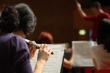 Musikutbildning Västerås. Bild visar musiker under utbildning som spelar flöjt vid notställ.